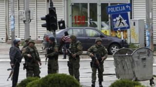 Police officers walk through a street near the scene of an altercation involving the police, in northern Macedonian town of Kumanovo, on Saturday, 9 May 2015