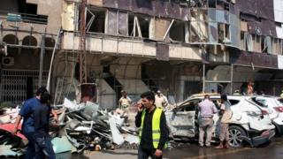 Iraqis gather at the scene of a car bomb attack at Kahramana Square in the Karada district of central Baghdad