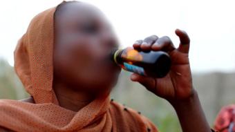 A woman drinking cough syrup