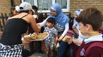 Woman handing out sandwiches to residents
