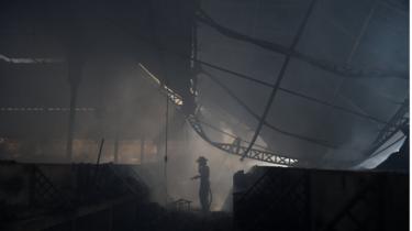 A firefighter stands amid the ruins of the Iron Market in Port au Prince.