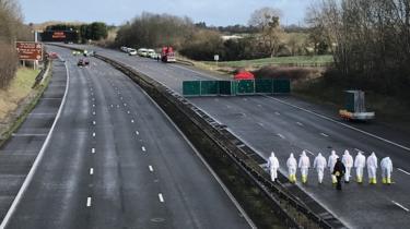 Forensic officers walk on the M5