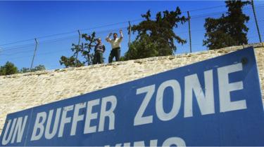 Turkish Cypriots look over the UN Buffer Zone into the Greek part of the divided city of Nicosia from the Turkish side on 25 April, 2004