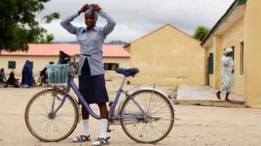 A student ties a scalf on her head as she prepares to ride a bicycle after the school hours at Hausari junior secondary school in Michika village, northeast Nigeria June 12, 2017