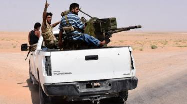 Pro-Syrian government militiamen sit in the back of an armed vehicle in Bir Qabaqib, west of Deir al-Zour (4 September 2017)