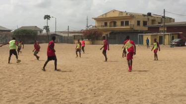 Boys playing football in an open space