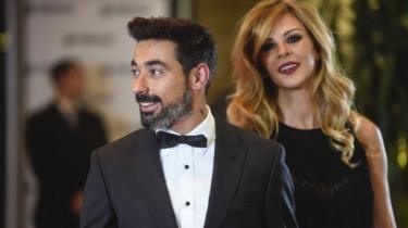 Argentine footballer Ezequiel Lavezzi and his wife pose on a red carpet upon arrival to attend Argentine football star Lionel Messi and Antonella Roccuzzo