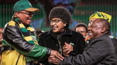 Former wife of the late South African President Nelson Mandela, Winnie Mandela (C) holds the hands of South African President Jacob Zuma (L) and South African Deputy President Cyril Ramaphosa (R) during the opening session of the South African ruling party African National Congress policy conference on June 30, 2017 in Johannesburg.