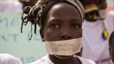 Sandy, 10, wears tape over her mouth as she joins women from more than 40 South Sudanese women's organisations as they march through the city to express the frustration and suffering that women and children face in Juba, South Sudan on December 9, 2017