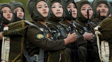 Female officers in a row holding guns