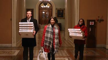 Three young people carry pizzas through the corridors of the US Capitol Building in this photo taken late on Thursday night