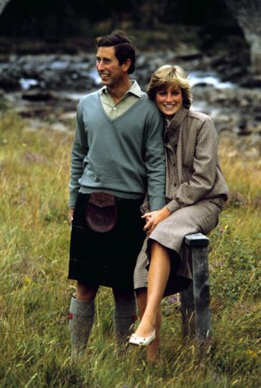 Charles and Diana sit together by the banks of a river