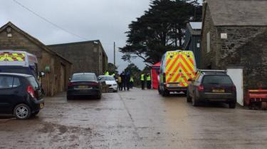 Police vehicles outside the farm