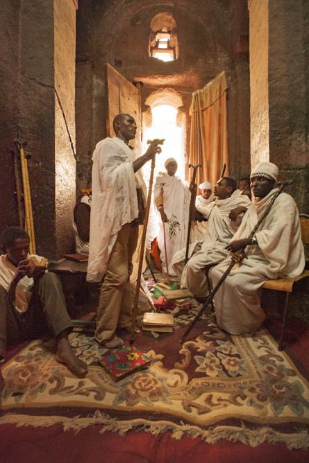 Congregación de rezo, canto y lectura de la Biblia en una iglesia de piedra tallada en Lalibela.