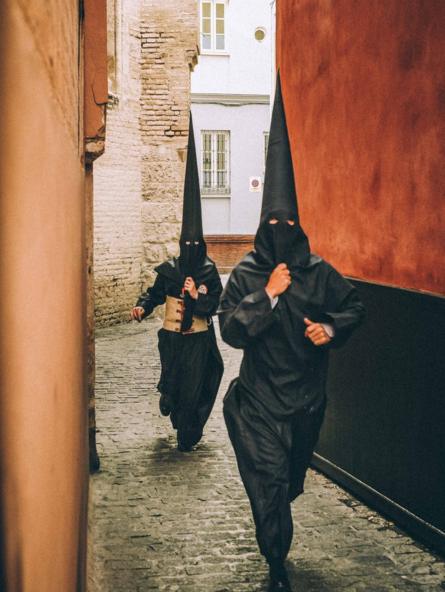 Dos feligreses llegando tarde a una procesión en Sevilla