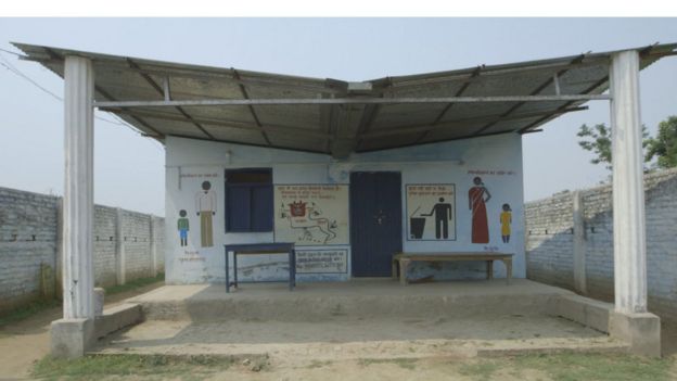 Exterior of toilet facility with images of men and women written on walls