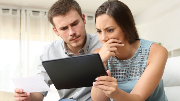 Un hombre y una mujer mirando una tablet