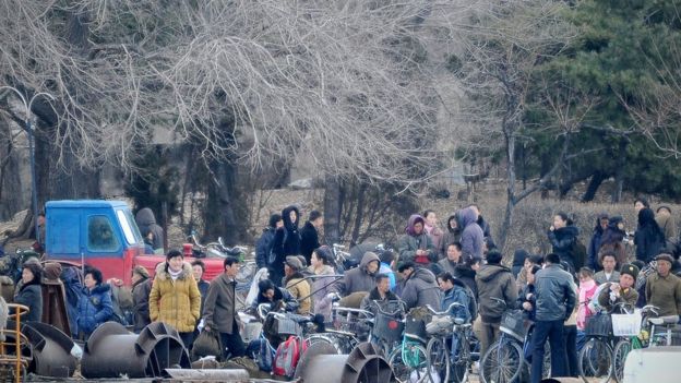 Decenas de personas en un paso fronterizo entre China y Corea del Norte junto al río Yalu.