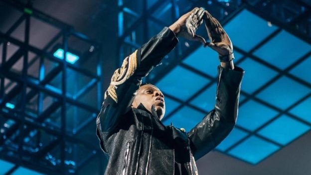 Jay Z haciendo el símbolo del triángulo con las manos