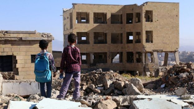 Niños yemeníes miran su escuela dañada en un bombardeo en la ciudad de Taez el pasado mes de marzo.
