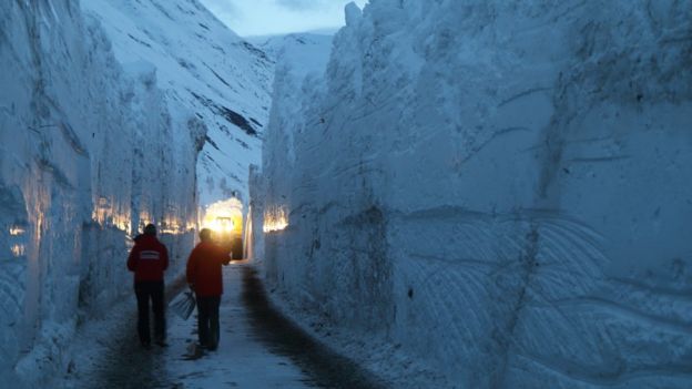 Workers cut through snow wall on the Bessans to Bonneval-sur-Arc road in France