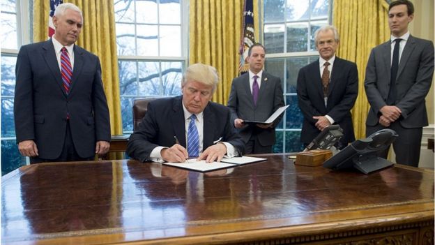 US President Donald Trump signs an executive order ending the US participation in the Trans-Pacific Partnership, alongside former White House Chief of Staff Reince Priebus, US Vice President Mike Pence and Senior Advisor Jared Kushner in the Oval Office of the White House