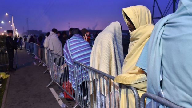Inmigrantes esperan en el puerto de Calais, en Francia.