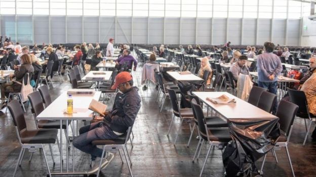 People wait in an exhibition hall serving as a shelter while evacuation measures are under way in Frankfurt (03 September 2017)