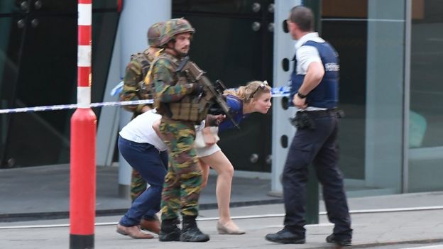 Soldiers and police officials guide members of the public on a street in Brussels, 20 June