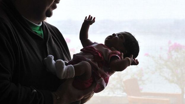 In this 19 February 2010 photograph, US citizen Brad Fister, 29, cradles his 23-day old daughter Ashton in Hyderabad.