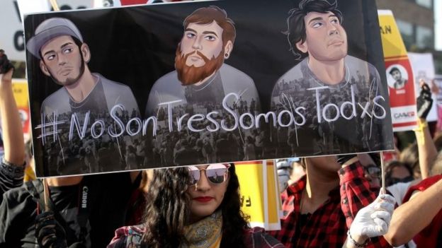 Manifestante seguram cartaz com a cara dos estudantes em protesto em Guadalajara