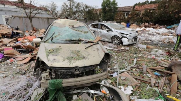 Two cars are pictured totally destroyed surrounded by debris