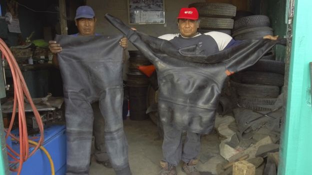 Willy y Enrique Quino muestran un traje de buzo hecho con llantas de camión