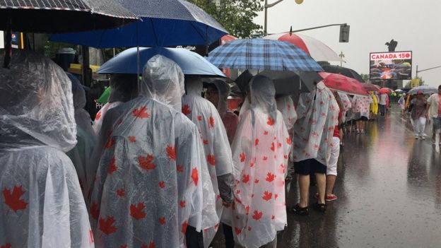 Canadians queue in the rain on Canada Day