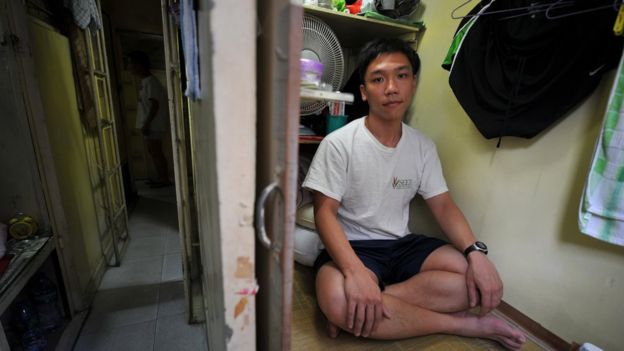 This photo taken on November 22, 2011 shows 25-year-old social worker Chan Siu-ming sitting in his living quarters at a government-licensed partitioned flat in Hong Kong.