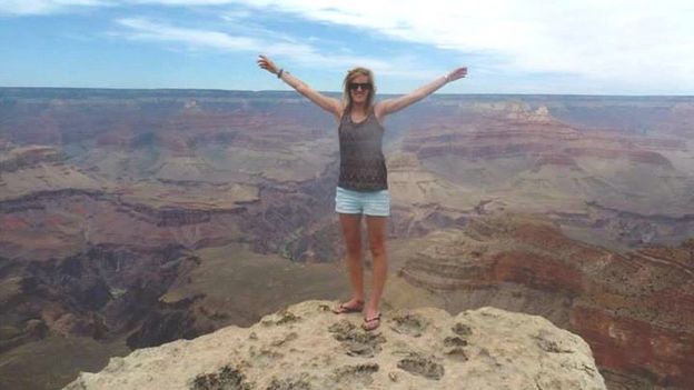Woman standing on a rock by the Grand Canyon