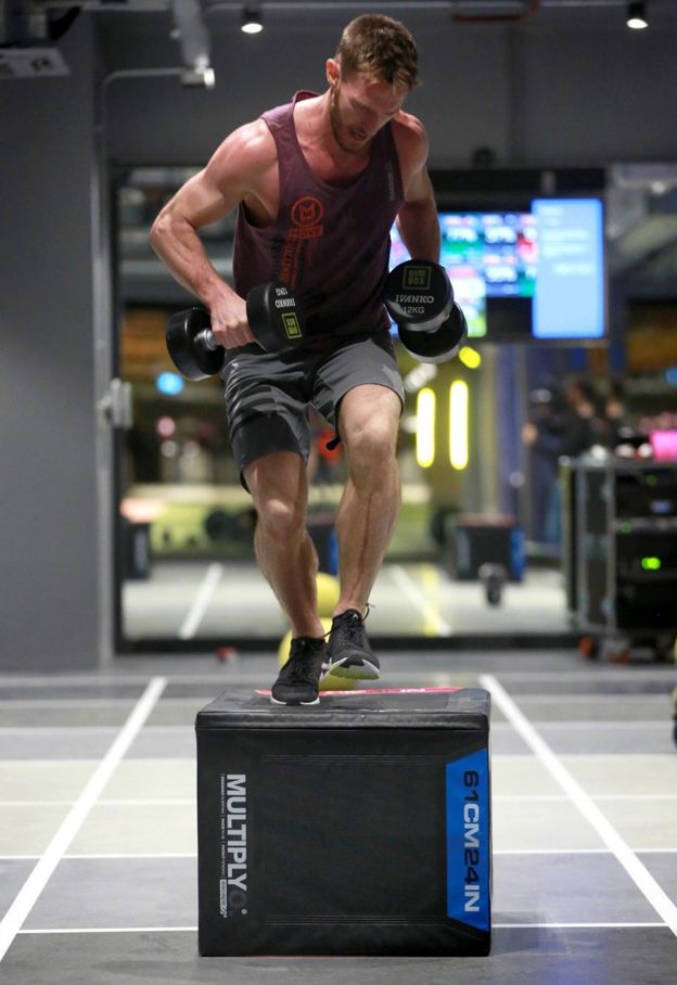 Un participante subiendo una caja.