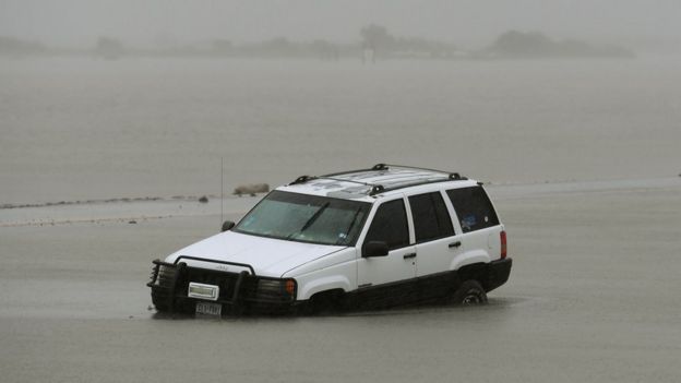 A white SUV car is seen submerged