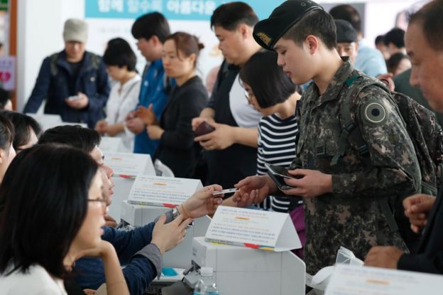 A soldier receives his ballot at a polling station in Seoul, South Korea, 4 May 2017.