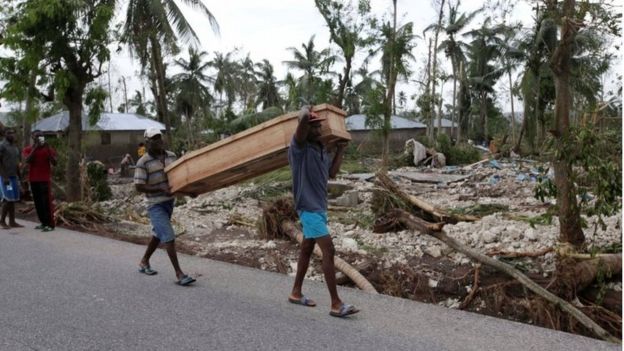 Men carry a coffin after Hurricane Matthew hit Cavaillon, Haiti, on 6 October 2016.