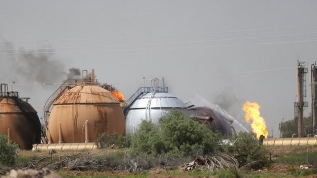 Flames and smoke rise from tanks after a suicide bomb attack on the Taji gas plant.