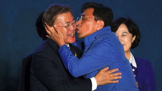 South Korean presidential candidate Moon Jae-in (L) of the Democratic Party receives a kiss from his party member Ahn Hee-Jung (R)