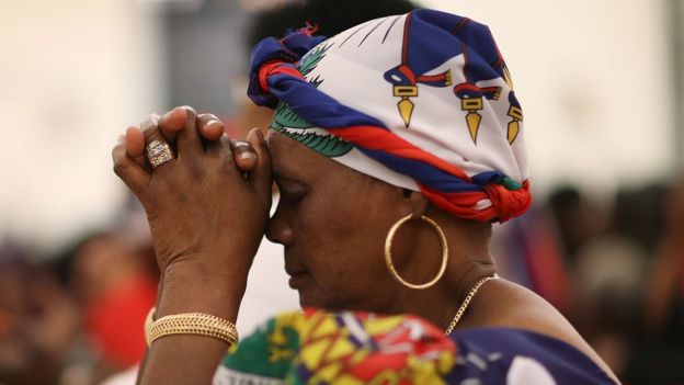 Mujer haitiana rezando.