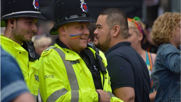 Policía en reino Unido con la bandera del movimiento homosexual pintada en el rostro.