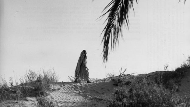 Mujer beduina camina por el Sahara.
