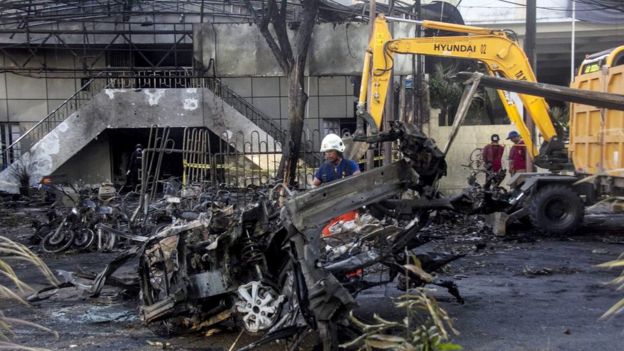 An Indonesian officer inspects the scene of a bomb blast in front of a church in Surabaya, East Java, Indonesia, 13 May 2018