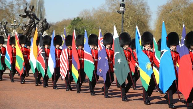 Soldiers of the Coldstream Guards carry flags of the 53 Commonwealth countries along The Mall outside Buckingham Palace