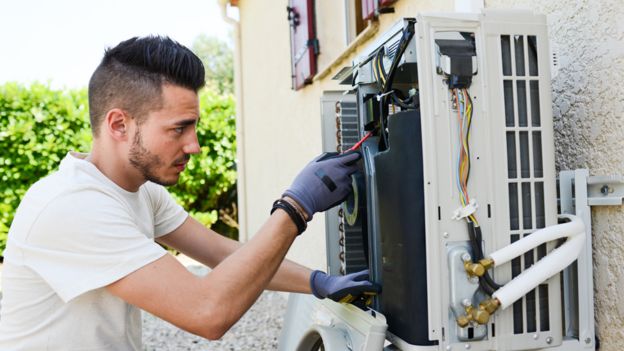 Hombre haciendo el mantenimiento de una unidad de aire acondicionado