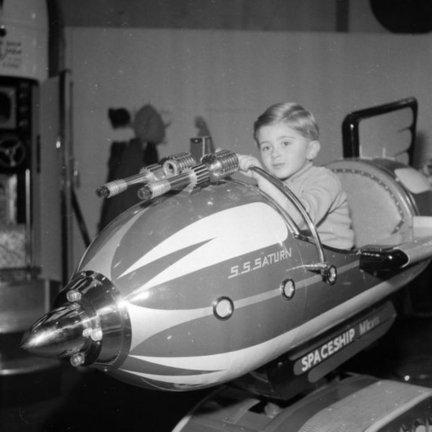 Un niño juega en una atracción que simula una nave espacial en 1968 en Londres.