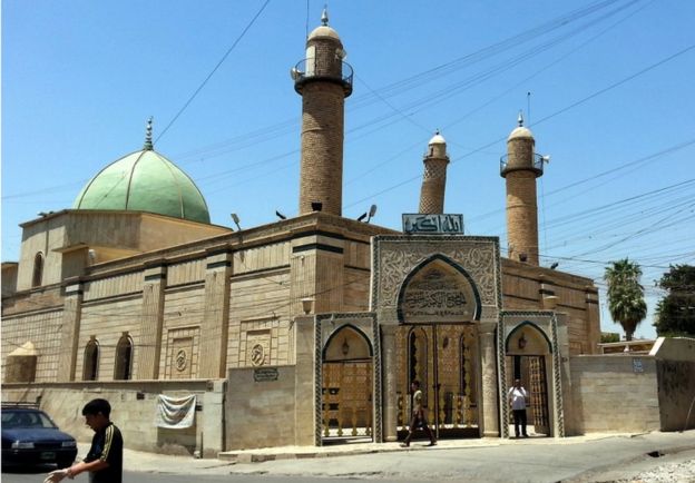 People walk in front of the Great Mosque of al-Nuri in Mosul, Iraq, 9 July 2014